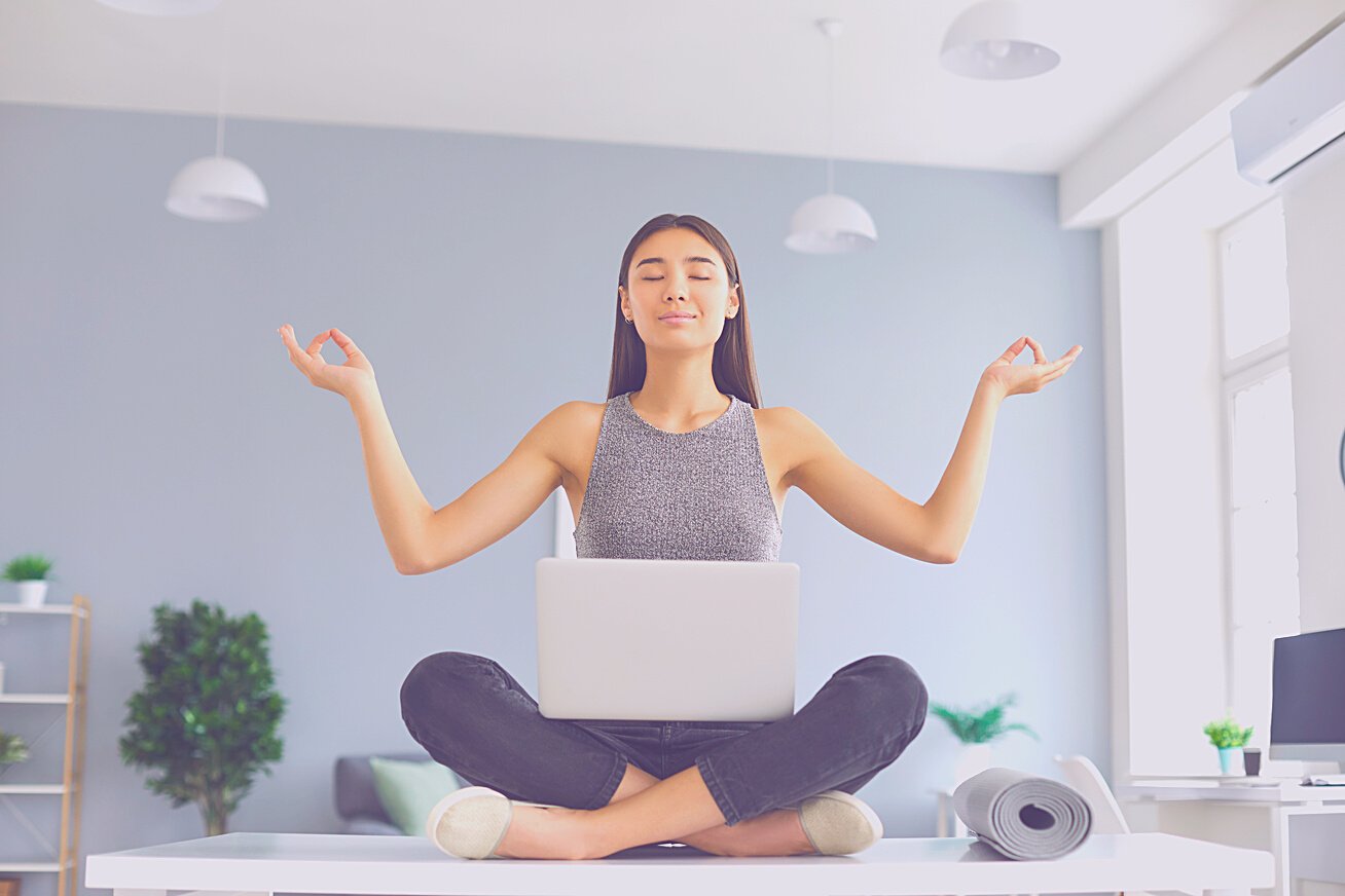 Office Worker with Positive Mindset Sitting on Desk in Easy Pose Meditating and Relaxing